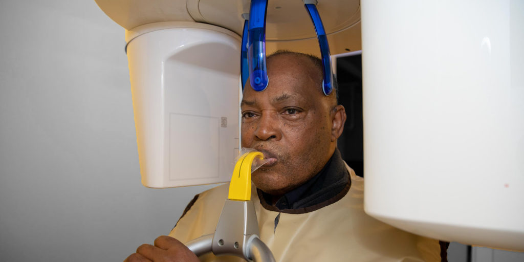 elderly african american patient undergoing a cbct scan for dental implants