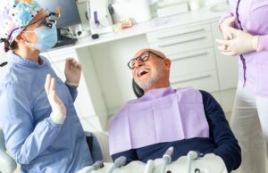 An inviting dental office reception area with modern decor, comfortable seating, and a friendly receptionist assisting a smiling patient. No text on the image.