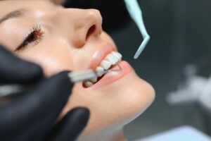A close-up of a smiling person receiving a dental exam. Gloved hands hold dental tools as the patient reclines, highlighting oral health care—paralleling the precision found in a content review dashboard.